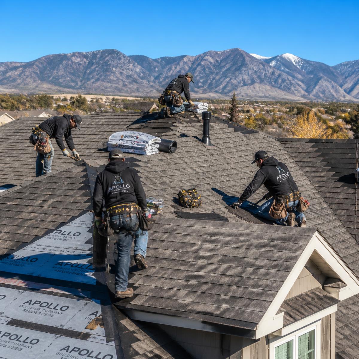 Summit Peak Roofing crew installing shingles on a Colorado home with mountains behind